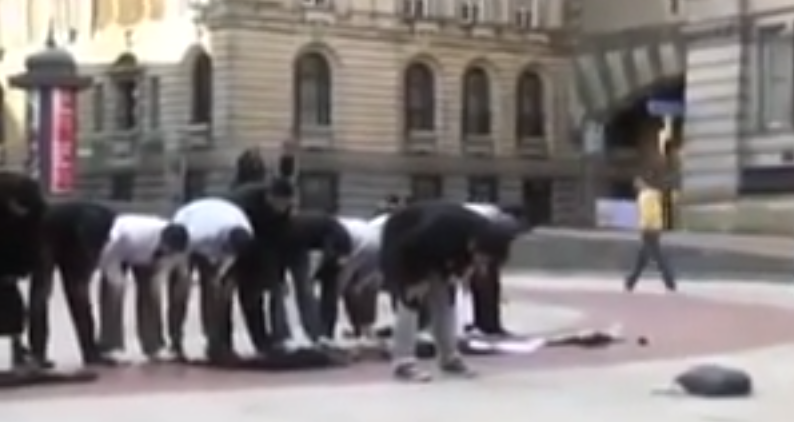 Muslim in prayer in street